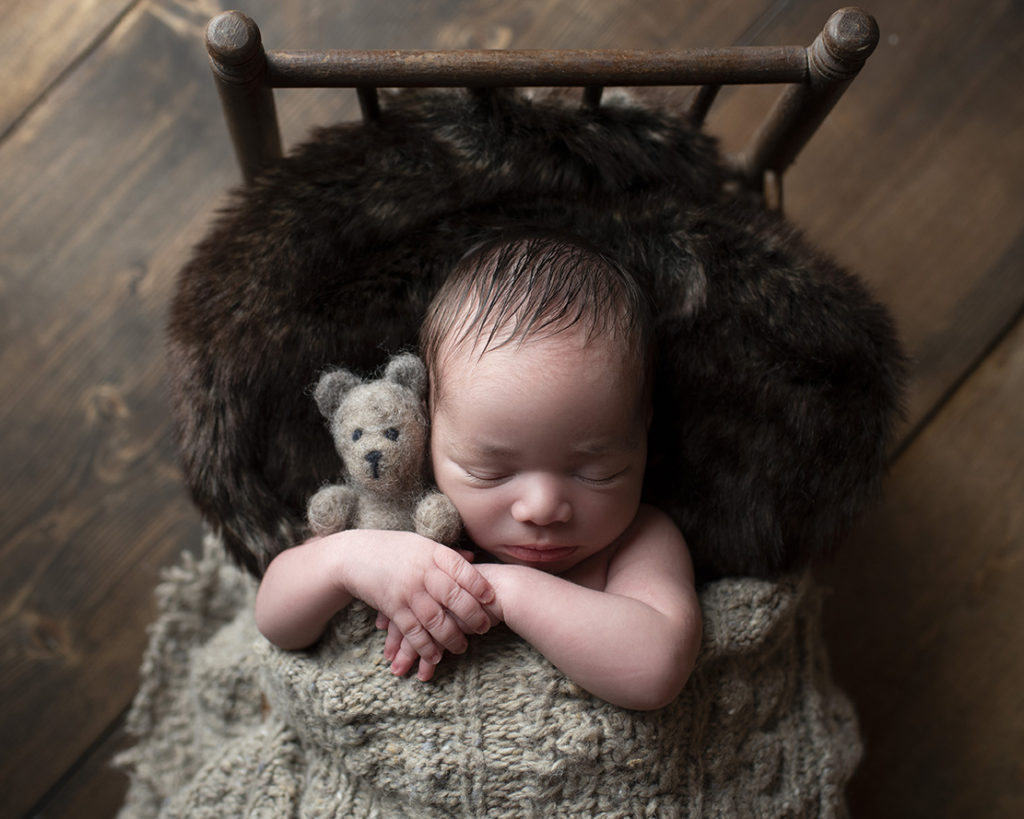 baby boy cuddling teddy bed